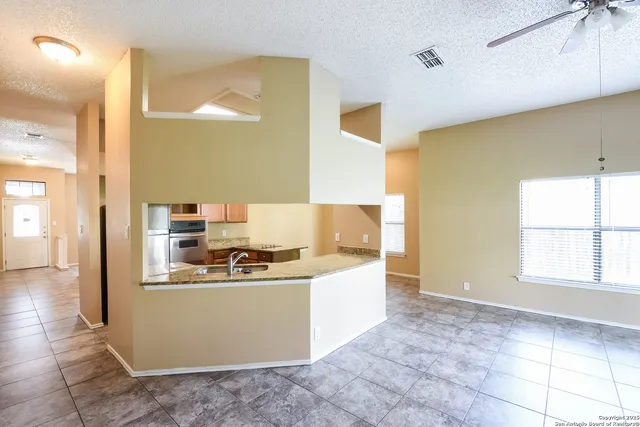 a kitchen with granite countertop a sink and a stove top oven