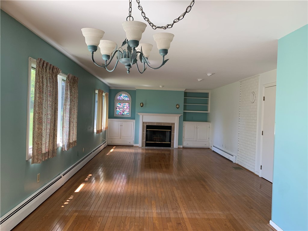 43 Lepes Road Portsmouth, RI 02871 - Photo 4 of 31 Located of the back is the formal living room with tile fireplace, sliders to deck and beautiful hardwood flooring.