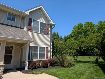 a front view of a house with a yard and trees