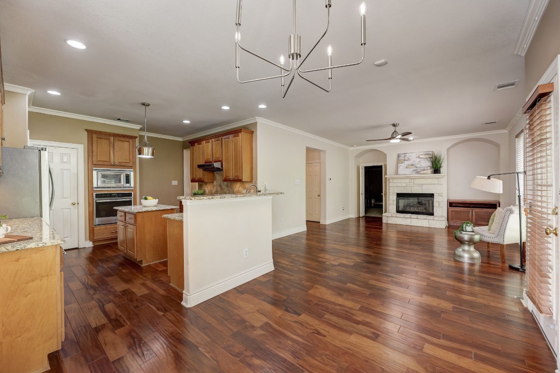 a view of kitchen with cabinets stainless steel appliances and wooden floor