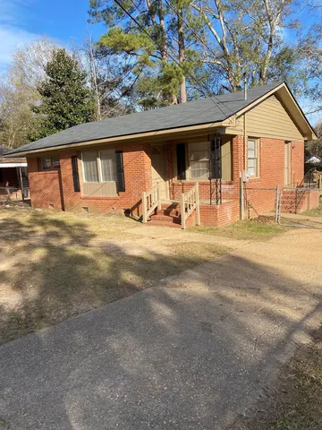 a view of a house with a patio and a yard