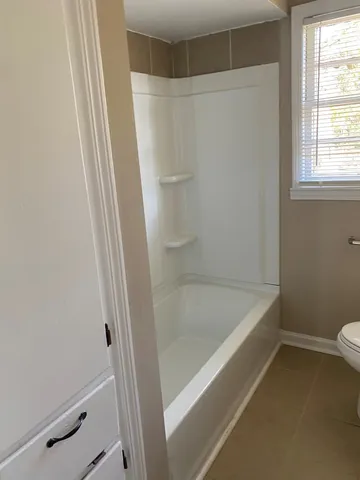 a bathroom with a bathtub and a toilet