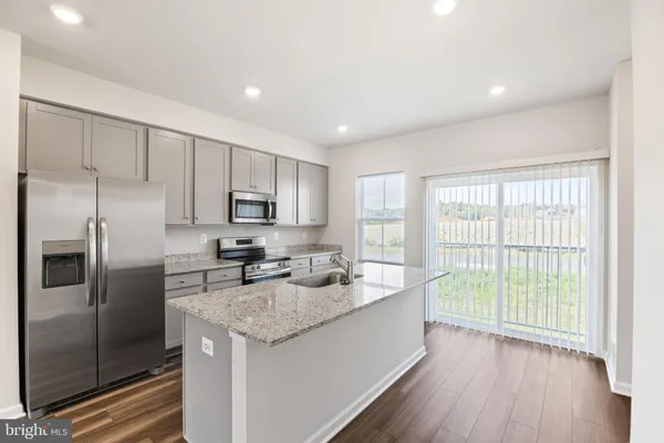 a kitchen with stainless steel appliances granite countertop a stove a sink and a refrigerator