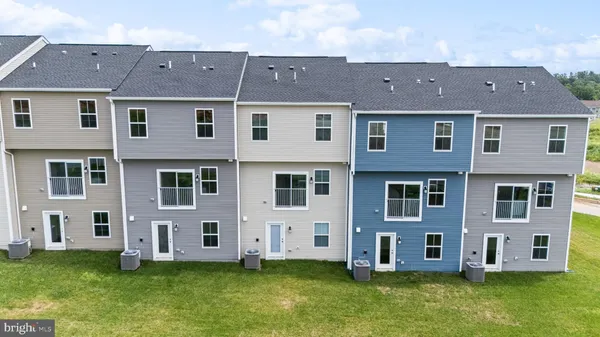 a aerial view of a brick house with a yard and large trees