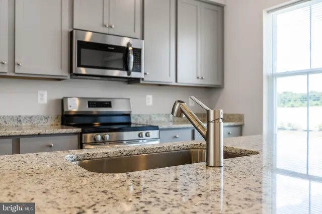 a kitchen with stainless steel appliances granite countertop white cabinets and a granite counter tops