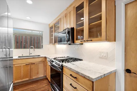 a kitchen with a sink stove top oven and cabinets