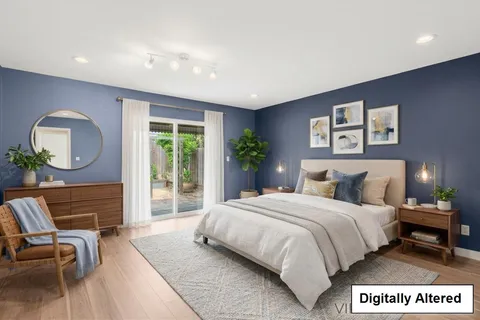 a bedroom with a bed a mirror and a large window