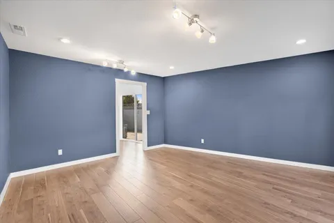 a view of an empty room with wooden floor