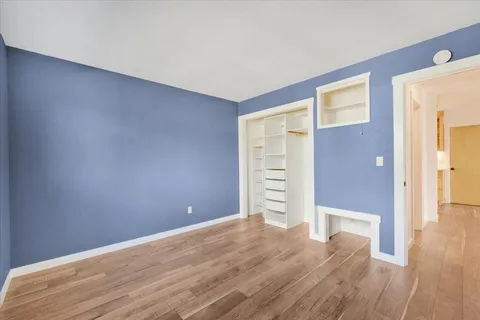 a view of an empty room with wooden floor