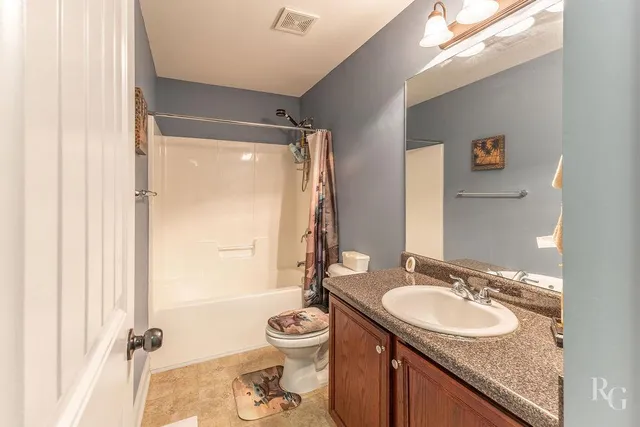 a bathroom with a granite countertop sink toilet mirror and shower
