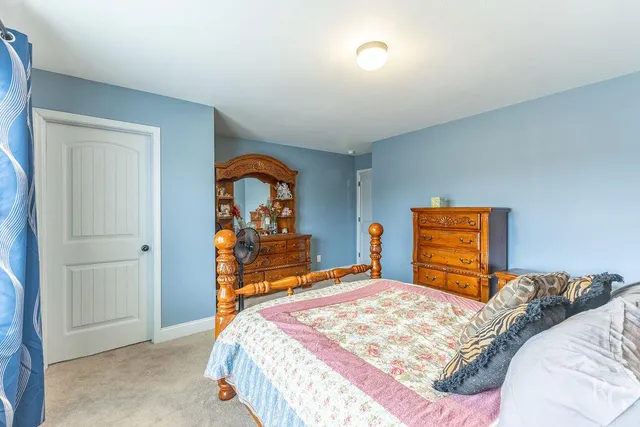 a bedroom with a bed and a dresser in it