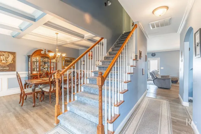 a view of a hallway with wooden floor and stairs