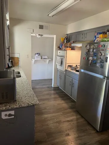 a kitchen with stainless steel appliances granite countertop a refrigerator and a stove
