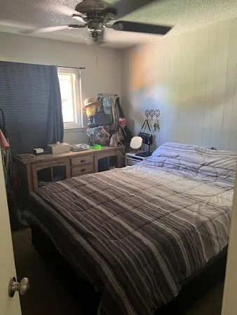 a bed sitting in a bedroom next to a window