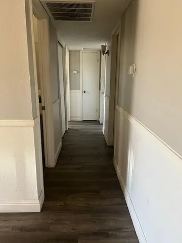 a view of a hallway with wooden floor and staircase