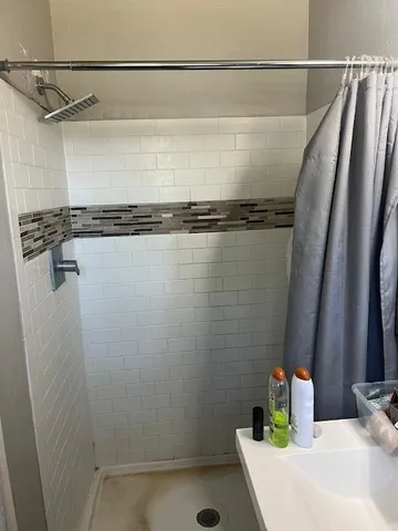 a bathroom with a shower and a sink