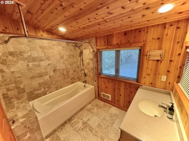 a bathroom with a tub a sink and a shower