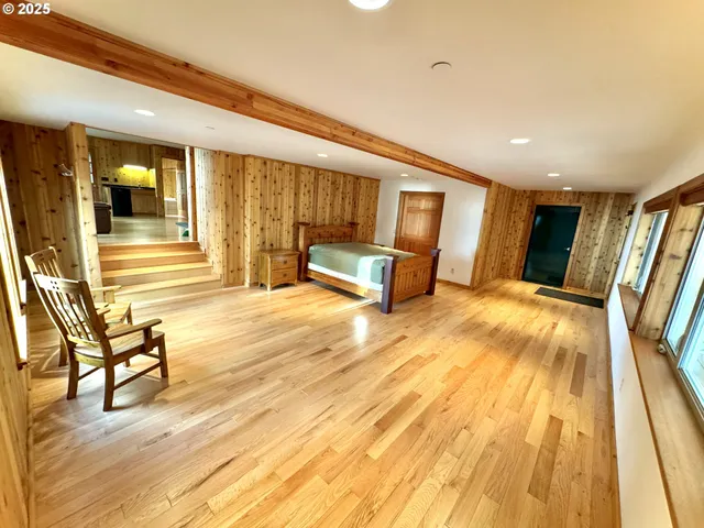 a spacious bedroom with a bed a table and chair