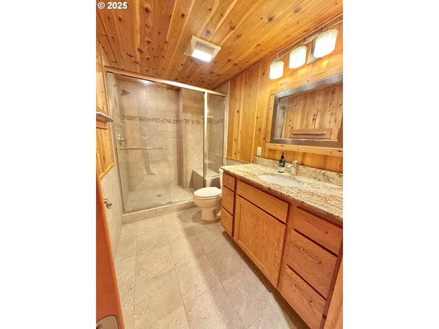 a spacious bathroom with a granite countertop sink a toilet and shower