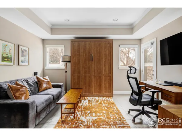 a living room with furniture a flat screen tv and a window