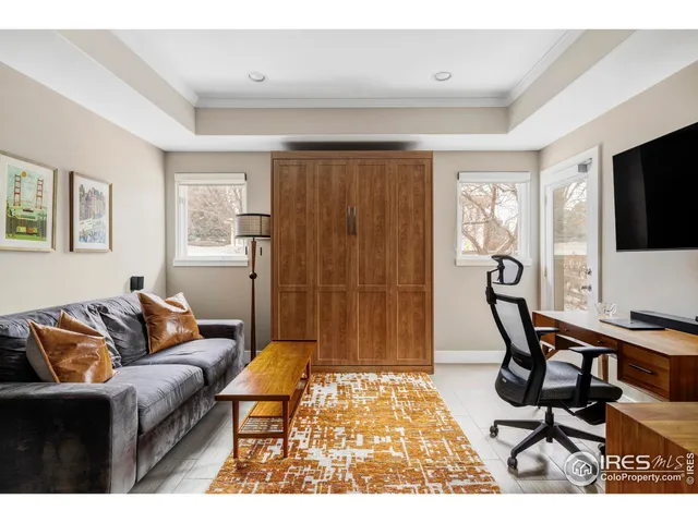 a living room with furniture a flat screen tv and a window