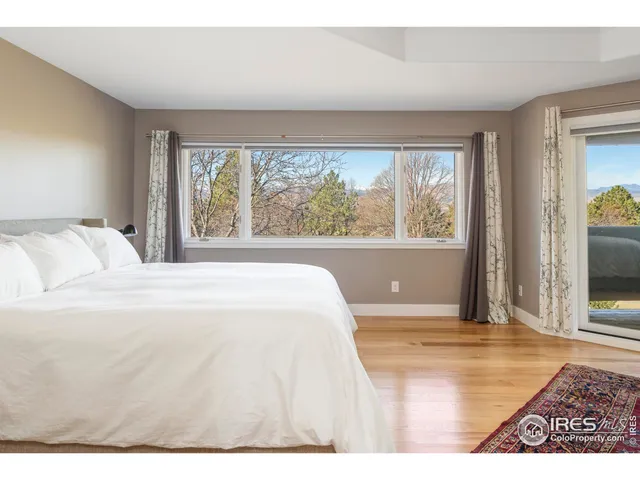 a view of a bedroom with wooden floor and a window