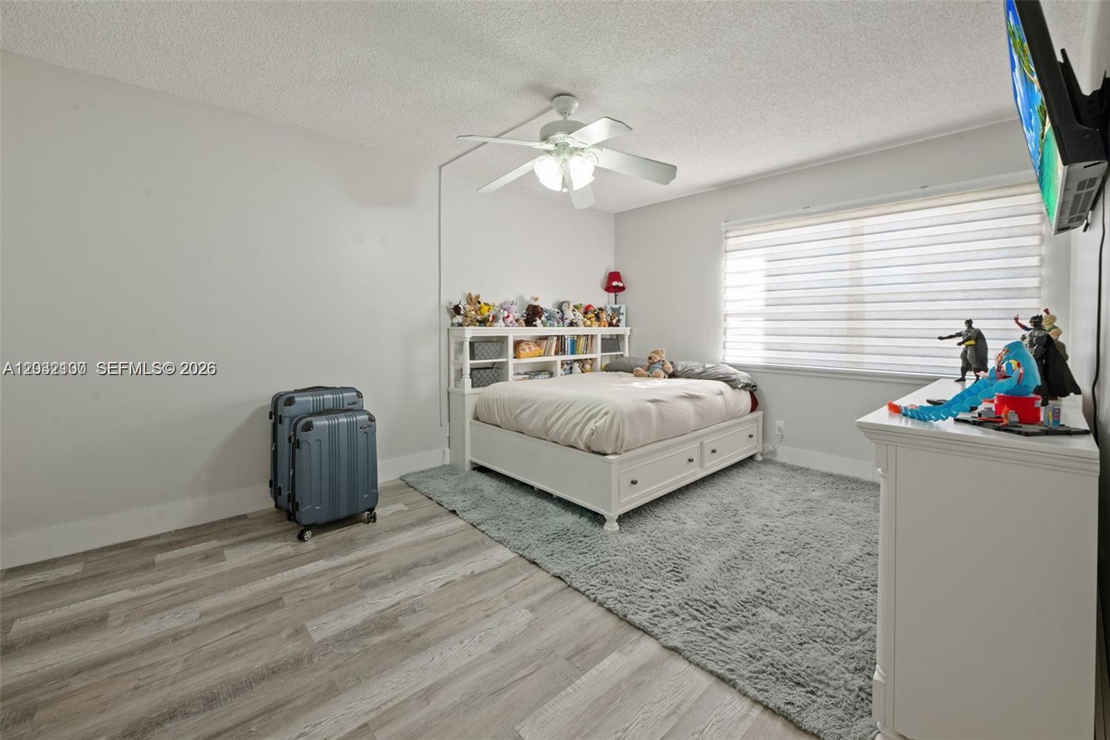 301 Racquet Club Road, Unit 104 Weston, FL 33326 - Photo 11 of 21 a spacious bedroom with a bed and a chandelier
