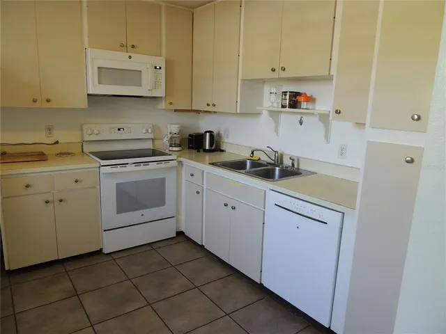 a view of a kitchen with white cabinets and a refrigerator