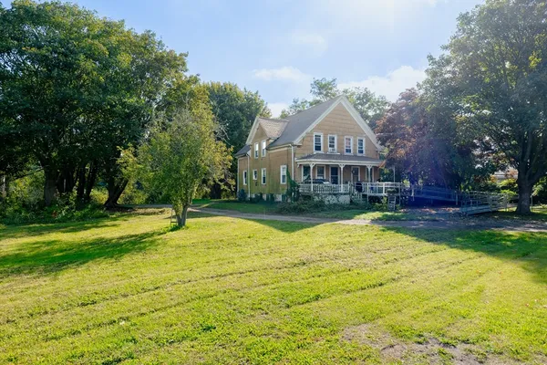 a view of a house with a yard and sitting area