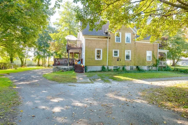 a view of a house with a yard and potted plants