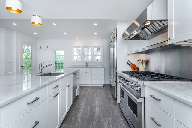 a kitchen with stainless steel appliances granite countertop a stove and a sink