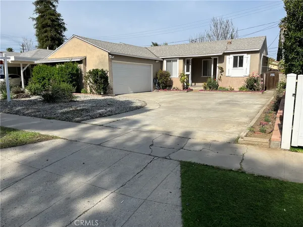 a front view of a house with a yard and potted plants