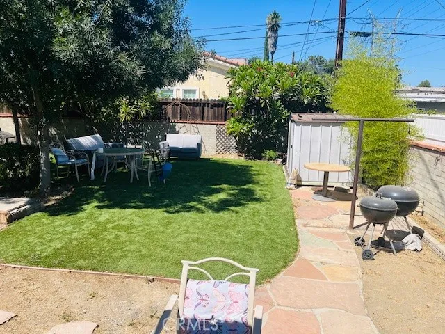 a view of a chairs and table in the backyard