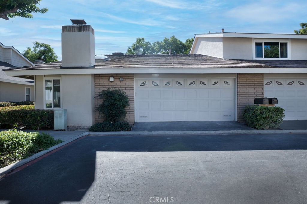 13 Brookmont, Unit 60 Irvine, CA 92604 - Photo 14 of 24 a front view of a house with a yard and garage