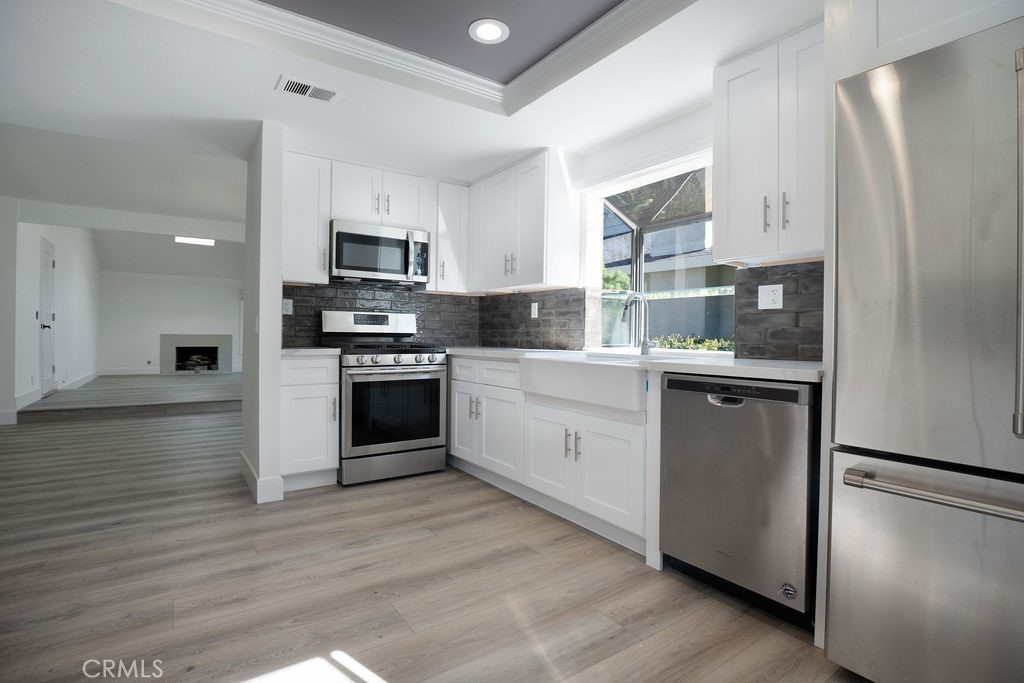 13 Brookmont, Unit 60 Irvine, CA 92604 - Photo 7 of 24 a kitchen with stainless steel appliances a refrigerator sink and microwave