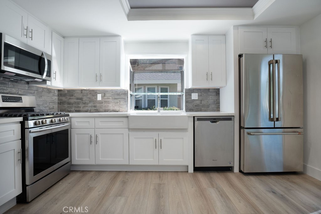 13 Brookmont, Unit 60 Irvine, CA 92604 - Photo 8 of 24 a kitchen with stainless steel appliances a refrigerator microwave and sink