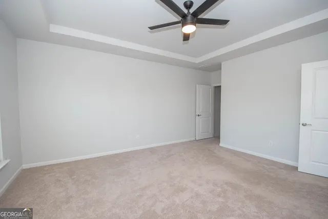 an empty room with a window and a fan
