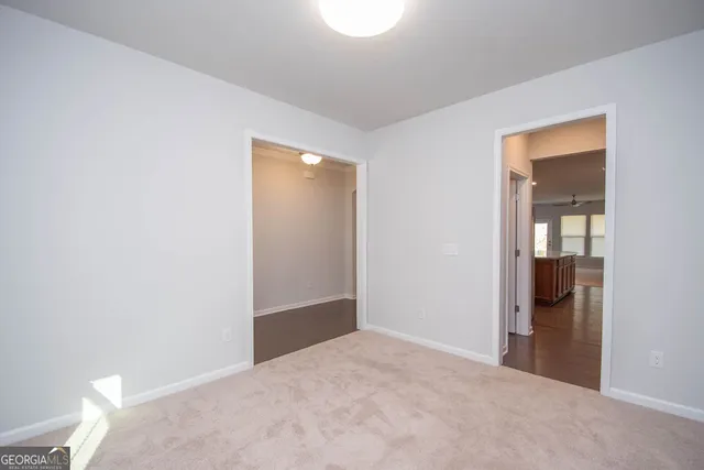a view of empty room with wooden floor and window