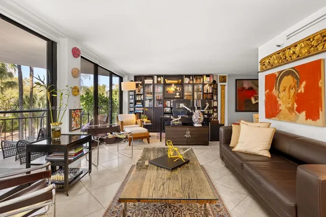 a living room with furniture hard wood floor and a floor to ceiling window