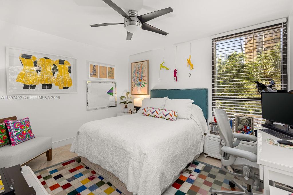 2843 South Bayshore Drive, Unit 4B Miami, FL 33133 - Photo 13 of 25 a bedroom with a bed a computer on the desk and a book shelf