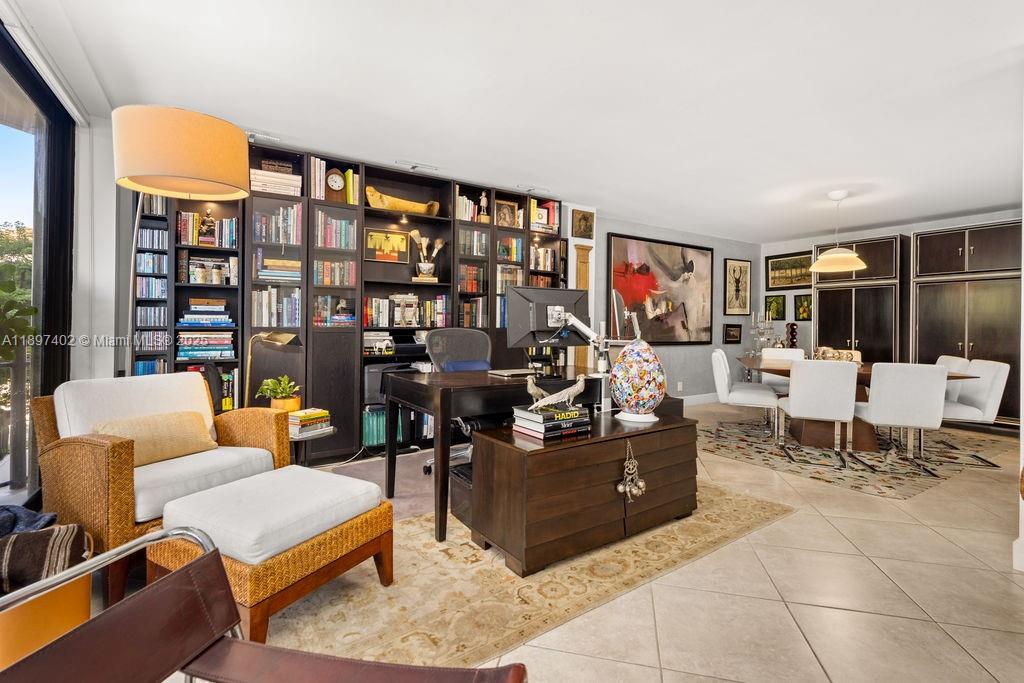 2843 South Bayshore Drive, Unit 4B Miami, FL 33133 - Photo 15 of 25 a living room with furniture a rug and a bookshelf