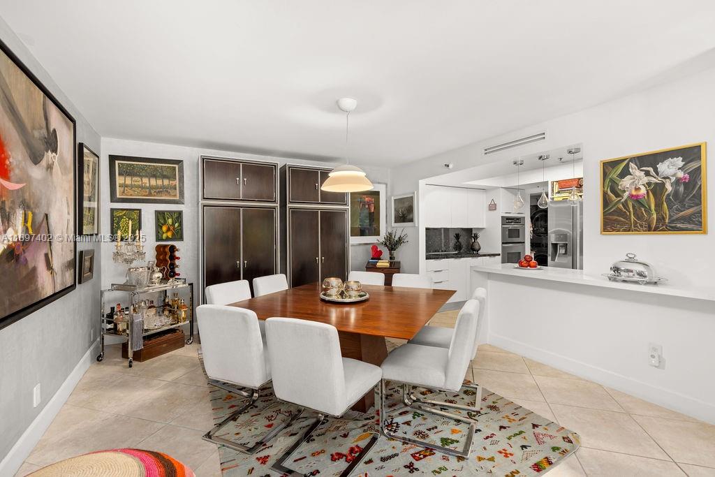 2843 South Bayshore Drive, Unit 4B Miami, FL 33133 - Photo 3 of 25 a dining room with furniture a rug and wooden floor