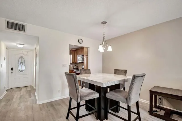 a view of a dining room with furniture wooden floor and chandelier