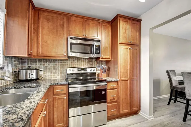a kitchen with granite countertop a refrigerator stove and microwave