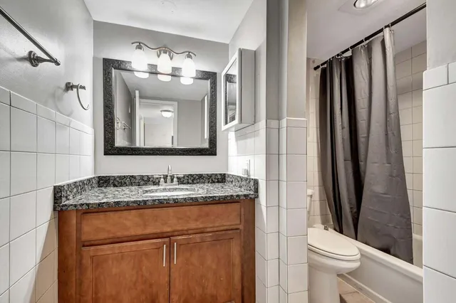 a bathroom with a granite countertop sink toilet and shower