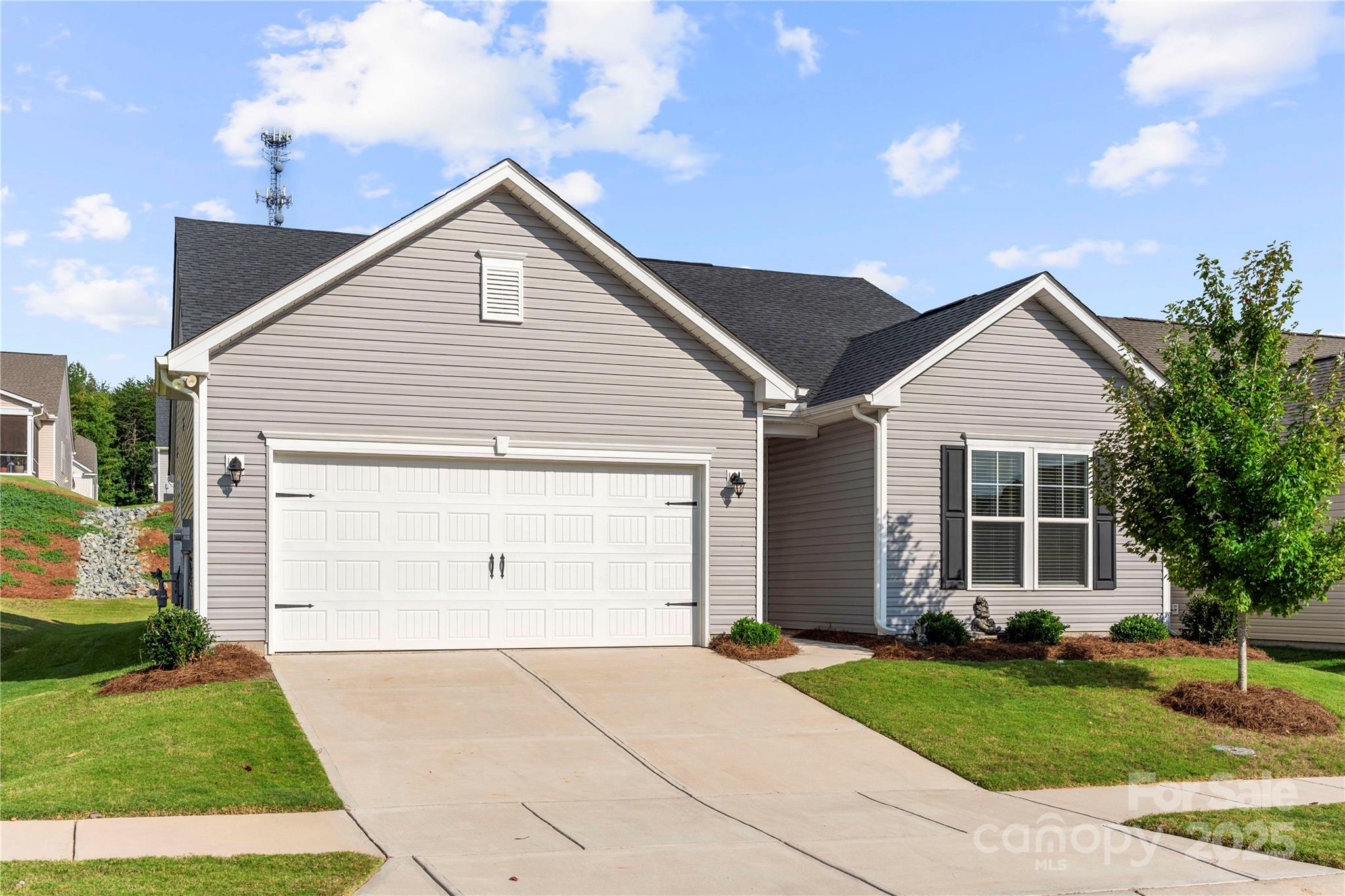 a view of a house with a yard and potted plants