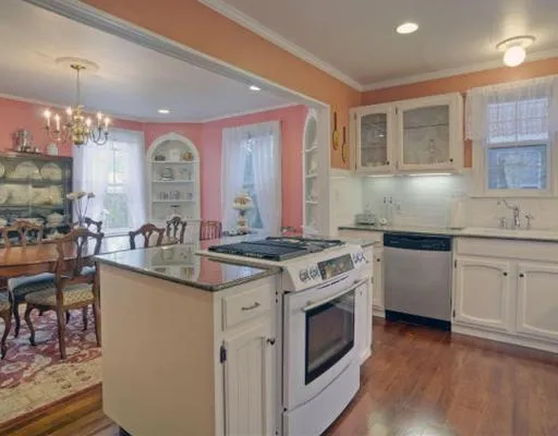 a kitchen with granite countertop a sink stove and cabinets