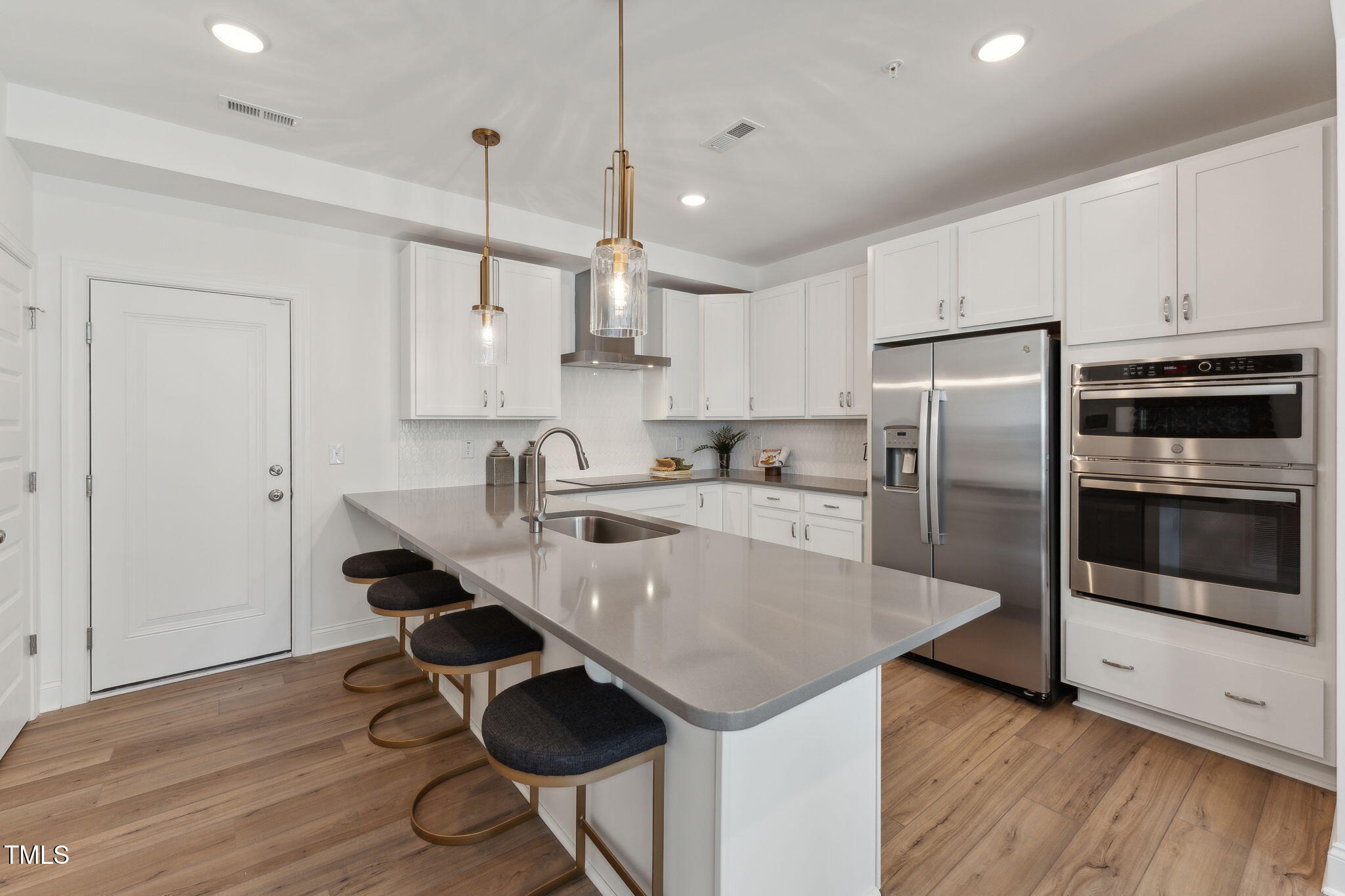 1232 South Person Street, Unit 101 Raleigh, NC 27601 - Photo 4 of 28 a kitchen with granite countertop a table chairs stainless steel appliances and wooden floor