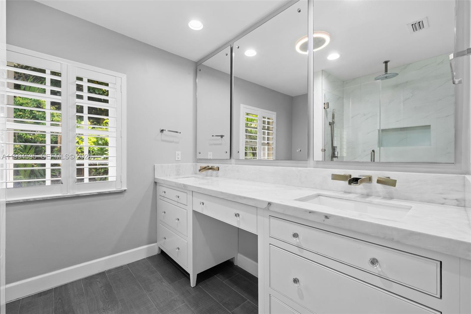 6801 Southwest 126th Terrace Pinecrest, FL 33156 - Photo 16 of 30 a bathroom with a double vanity sink and a mirror