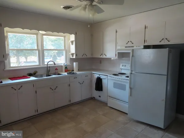 a kitchen with cabinets appliances a sink and a window